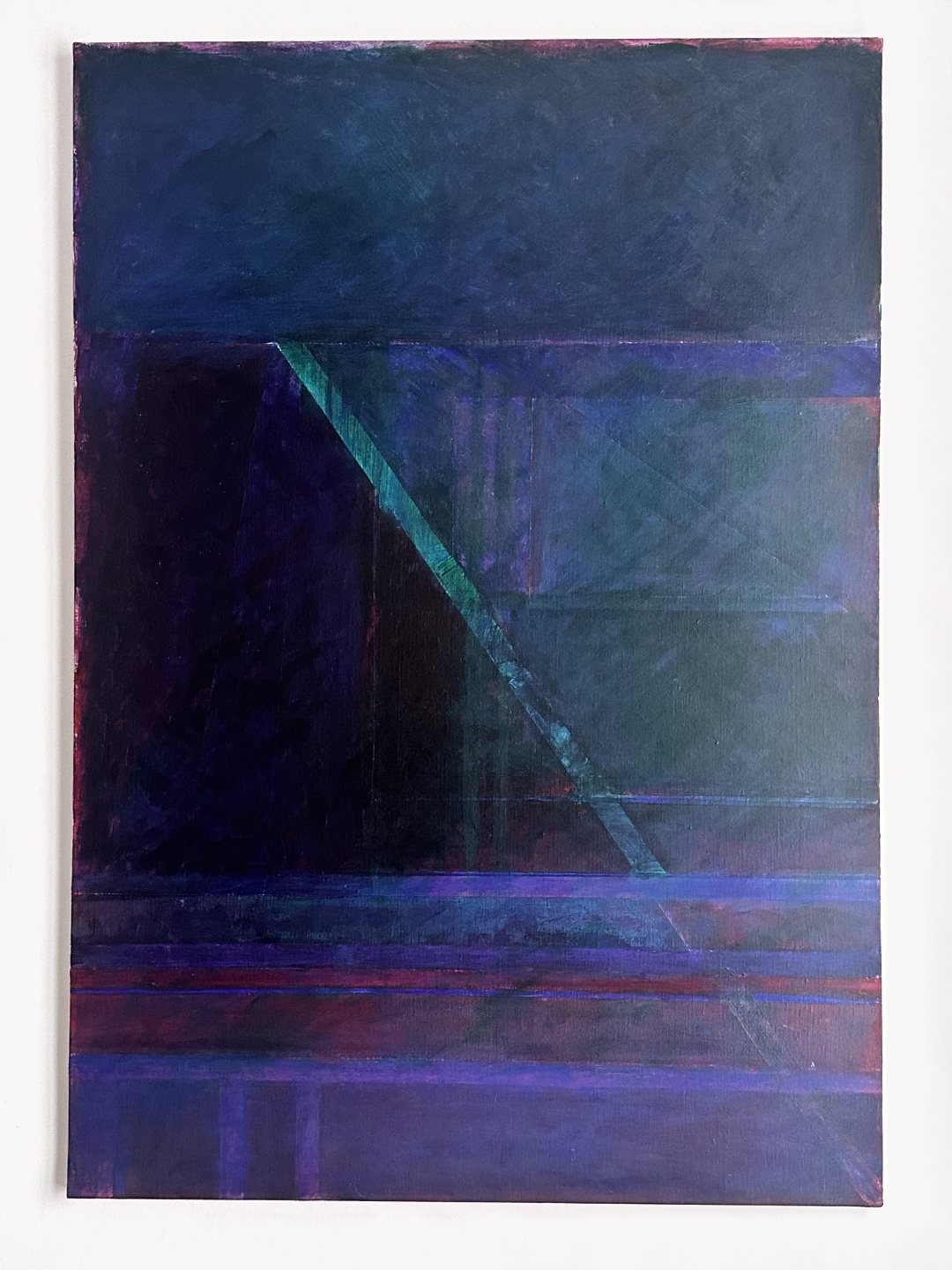 Une toile abstraite aux bleus et violets profonds, traversée en biais par une fine diagonale verte, accrochée seule sur un mur clair.